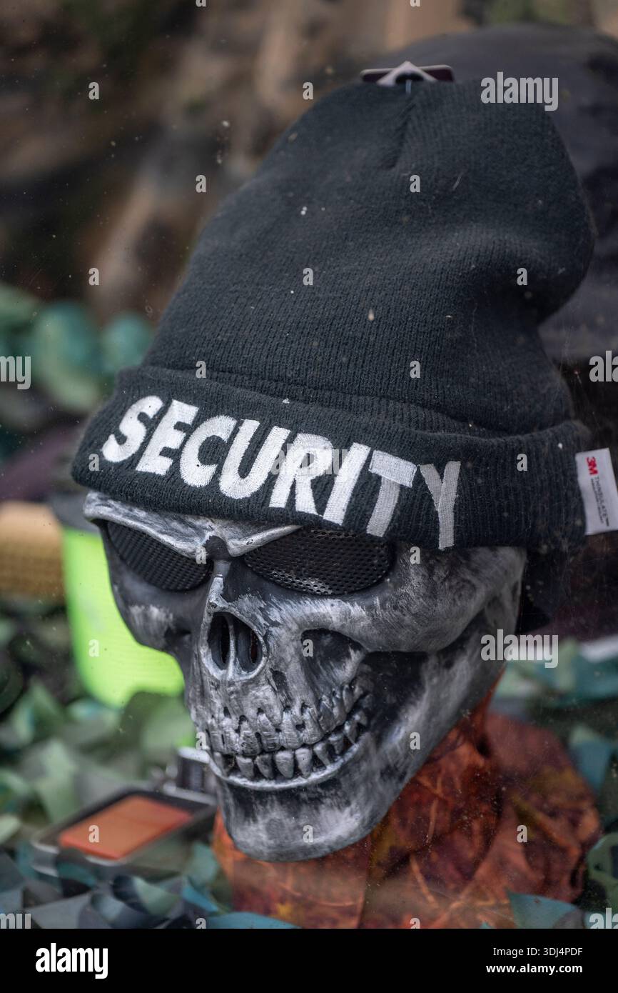 Modello di teschio umano che indossa un cappello di lana nera con "SICUREZZA" scritta sul davanti, modello di guardia di sicurezza in forma di cranio umano. Foto Stock