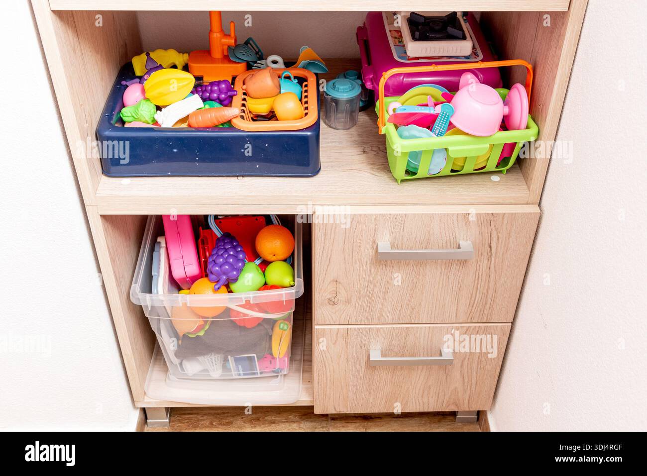 Riporre i giocattoli per bambini in contenitori in armadi mobili, sala giochi per bambini Foto Stock