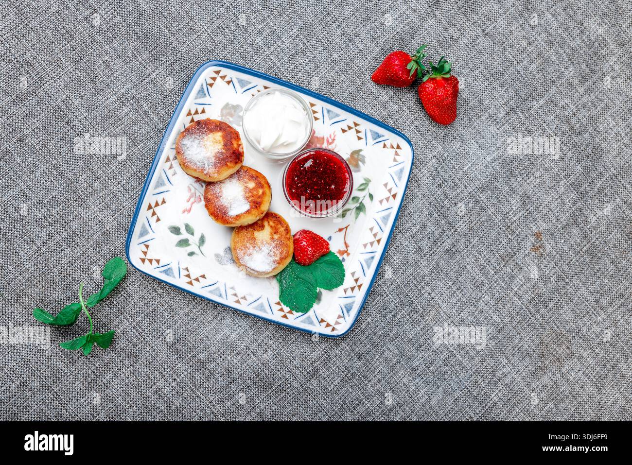 Primo piano di tre sciroppi dorati, una popolare colazione o un piatto da dessert dell'Europa orientale a base di quark/formaggio fresco, servito su un piatto bianco W. Foto Stock