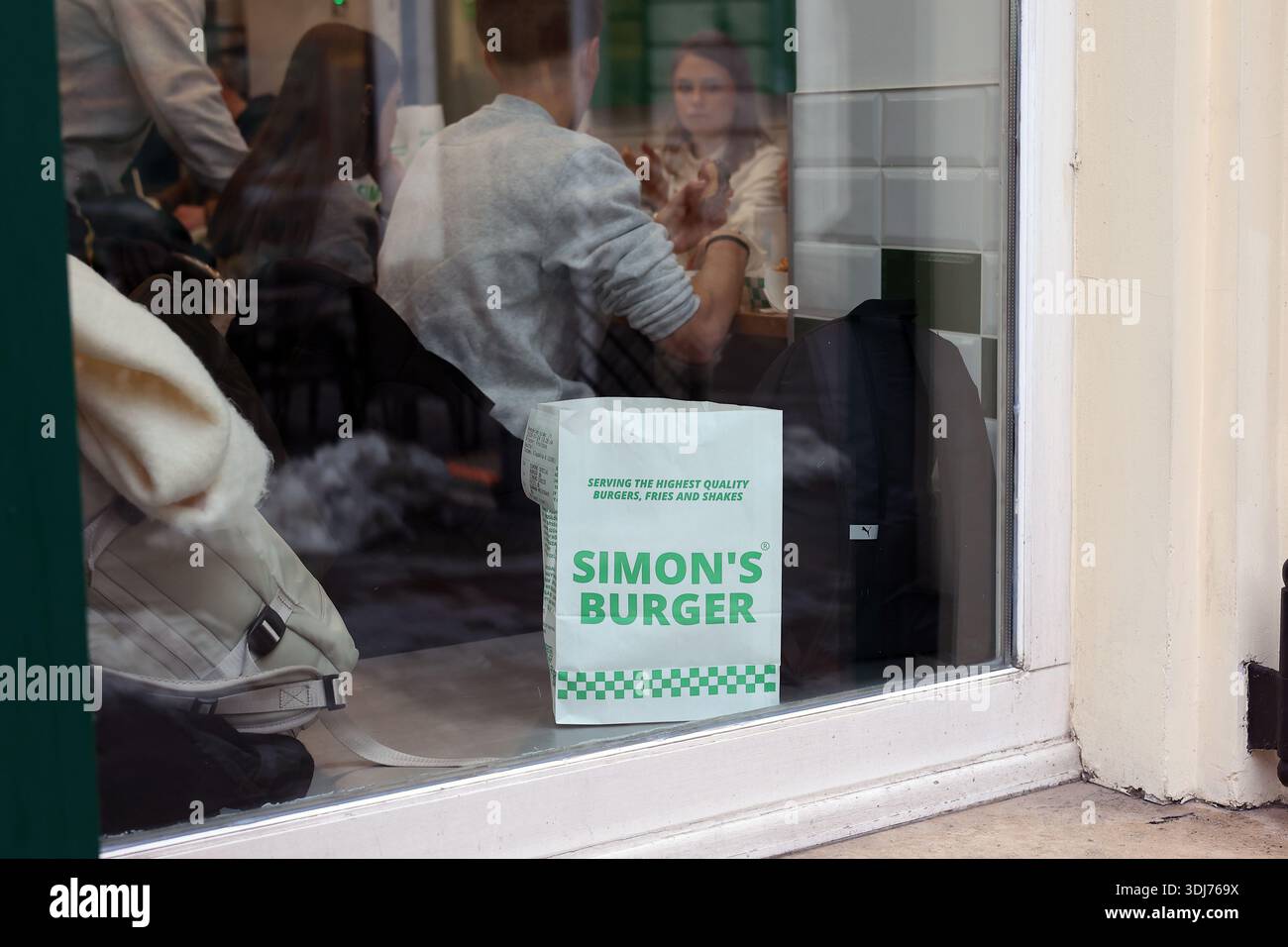 Borsa da asporto della catena di fast-food ungherese Simon's Burger vista dalla vetrina del ristorante di Budapest, Ungheria Foto Stock