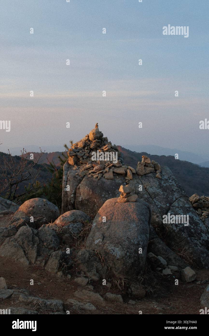 Cairn di pietra sul monte Biseulsan durante la calma alba, in Corea del Sud Foto Stock