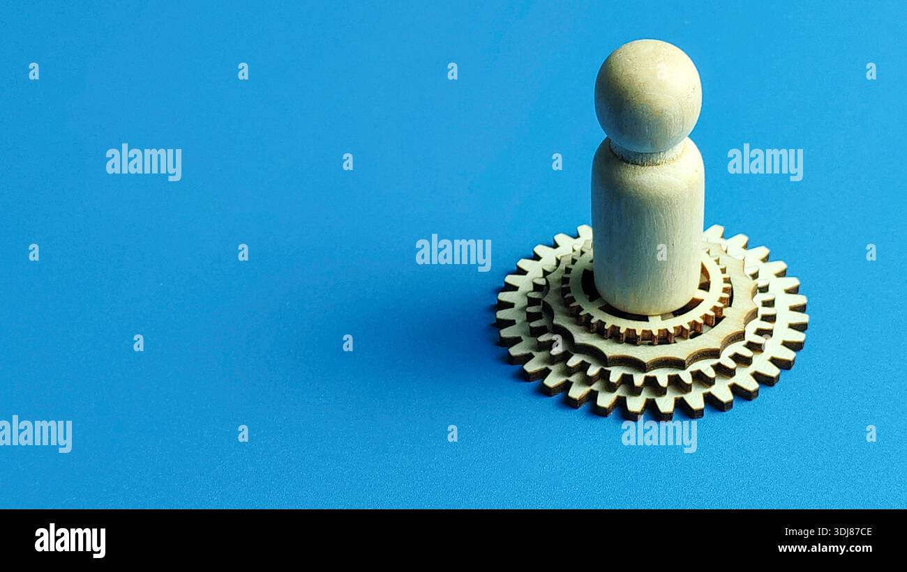 Avanzamento di carriera e crescita professionale con figure in legno in piedi su una gerarchia di ingranaggi a più livelli Foto Stock