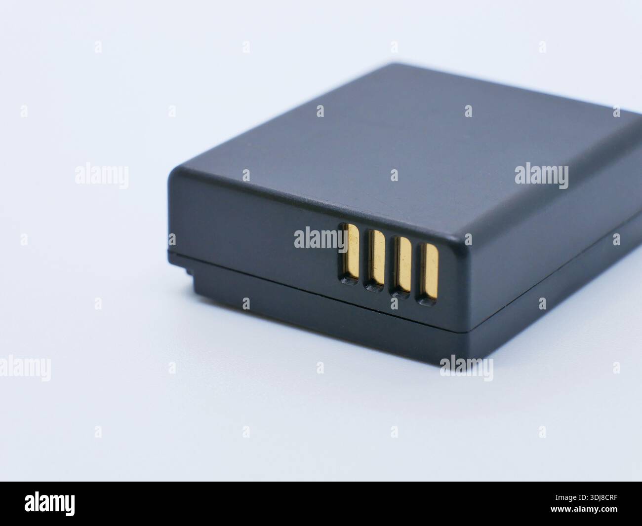 Batteria ricaricabile per fotocamera con contatti dorati isolati su sfondo bianco. Alimentazione per fotocamere e dispositivi digitali. Fotografia, elettroni Foto Stock