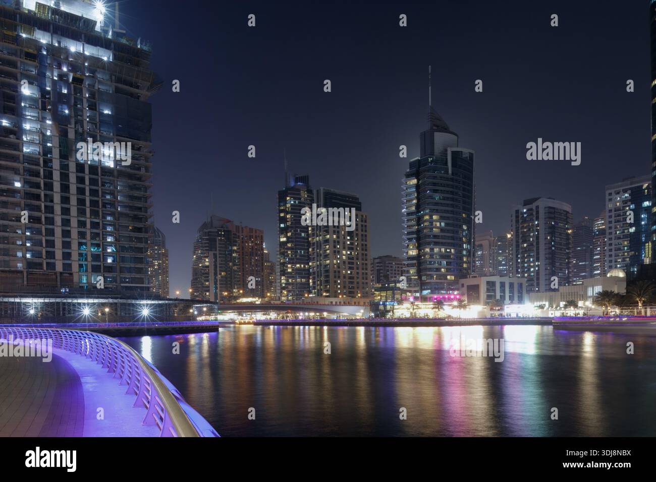 Dubai Marina, Emirati Arabi Uniti - 13 marzo 2025: Dubai Marina dispone di moderni grattacieli illuminati di notte, che riflettono sulla superficie dell'acqua wi Foto Stock