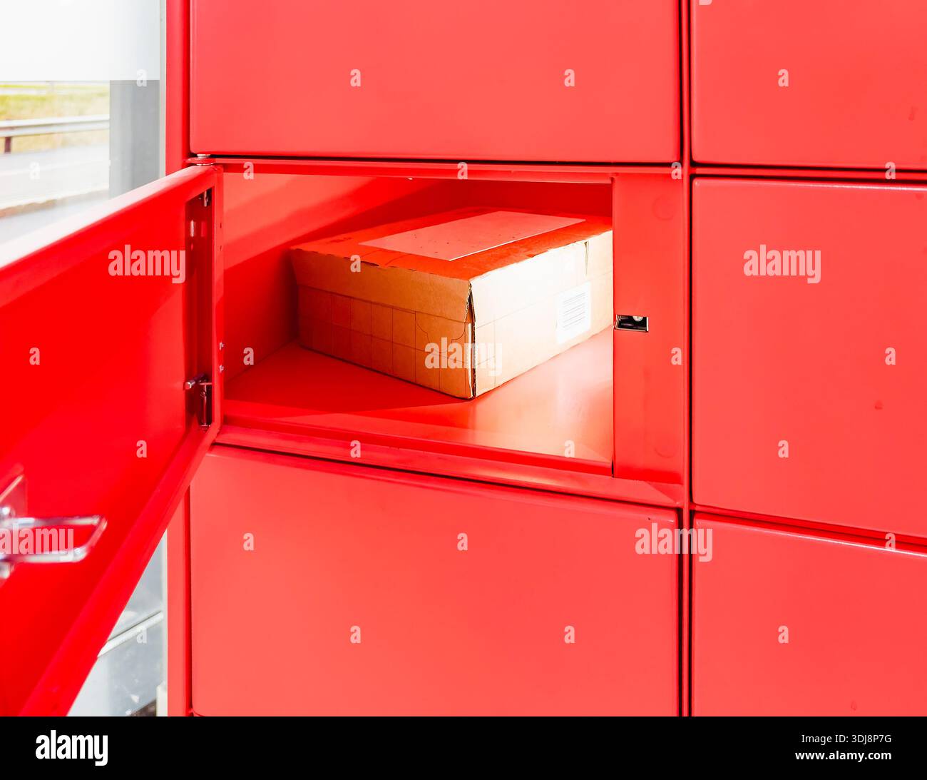Porsgrunn, Norvegia - 20 ottobre 2025: Il sistema di armadietti Red Instabox è dotato di una porta aperta con una scatola di cartone all'interno, che illustra lo stoccaggio sicuro dei pacchi Foto Stock