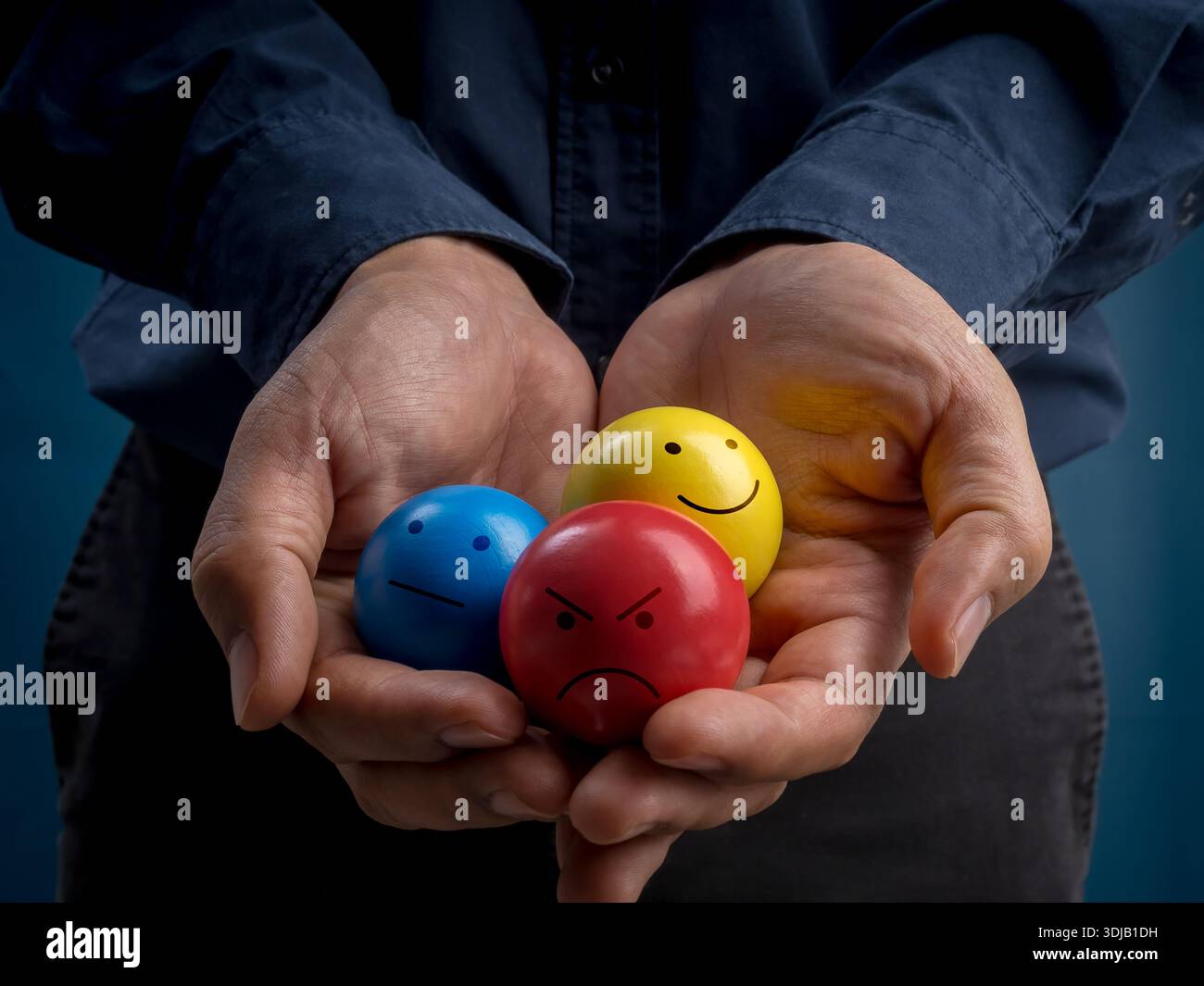 Mani con palle emozionali colorate con volti felici, neutri e arrabbiati, che rappresentano consapevolezza della salute mentale, feedback emotivo, esperienza utente, Foto Stock