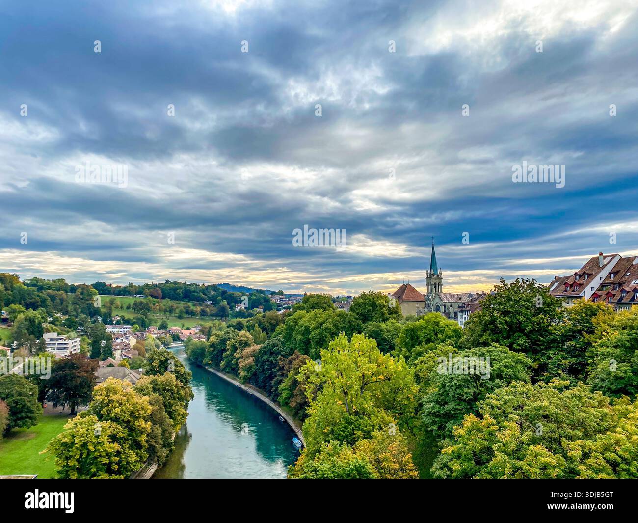 Una vista panoramica sul turchese fiume Aare che scorre attraverso la città di Berna, in Svizzera. L'immagine cattura il lussureggiante albero verde - Immagine stock catturata con smartphone