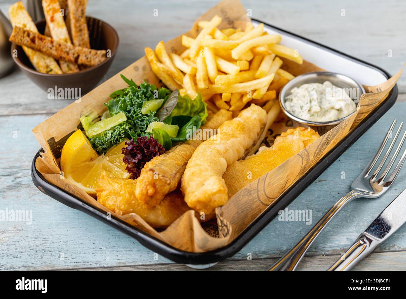 Classico fish and chips servito con patatine fritte e salsa Foto Stock