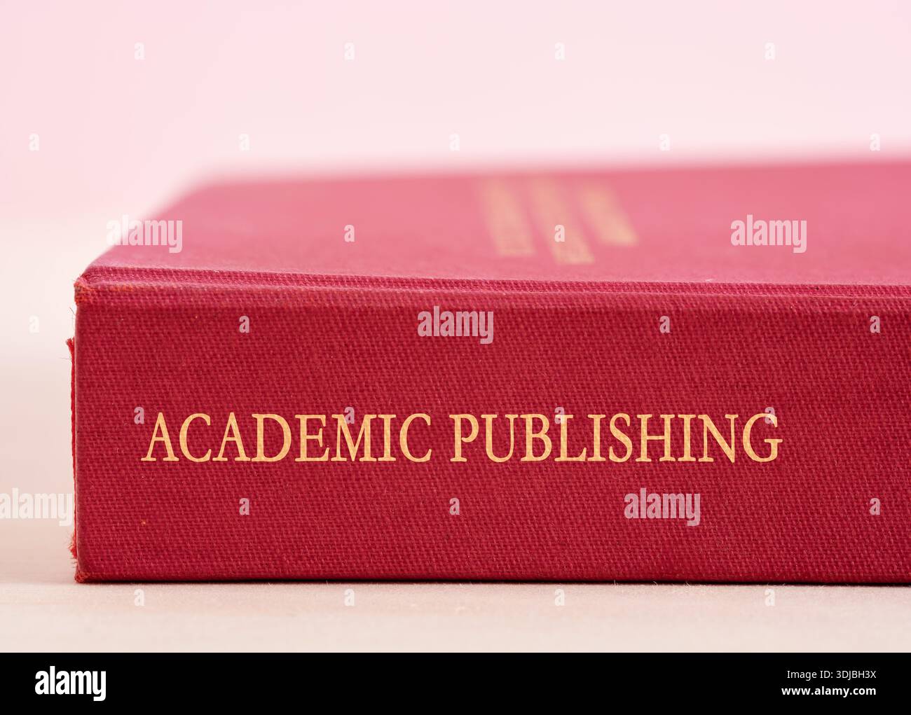 Primo piano di un libro rosso con Academic Publishing scritto sulla spina dorsale, che sottolinea il lavoro accademico e la diffusione della conoscenza Foto Stock