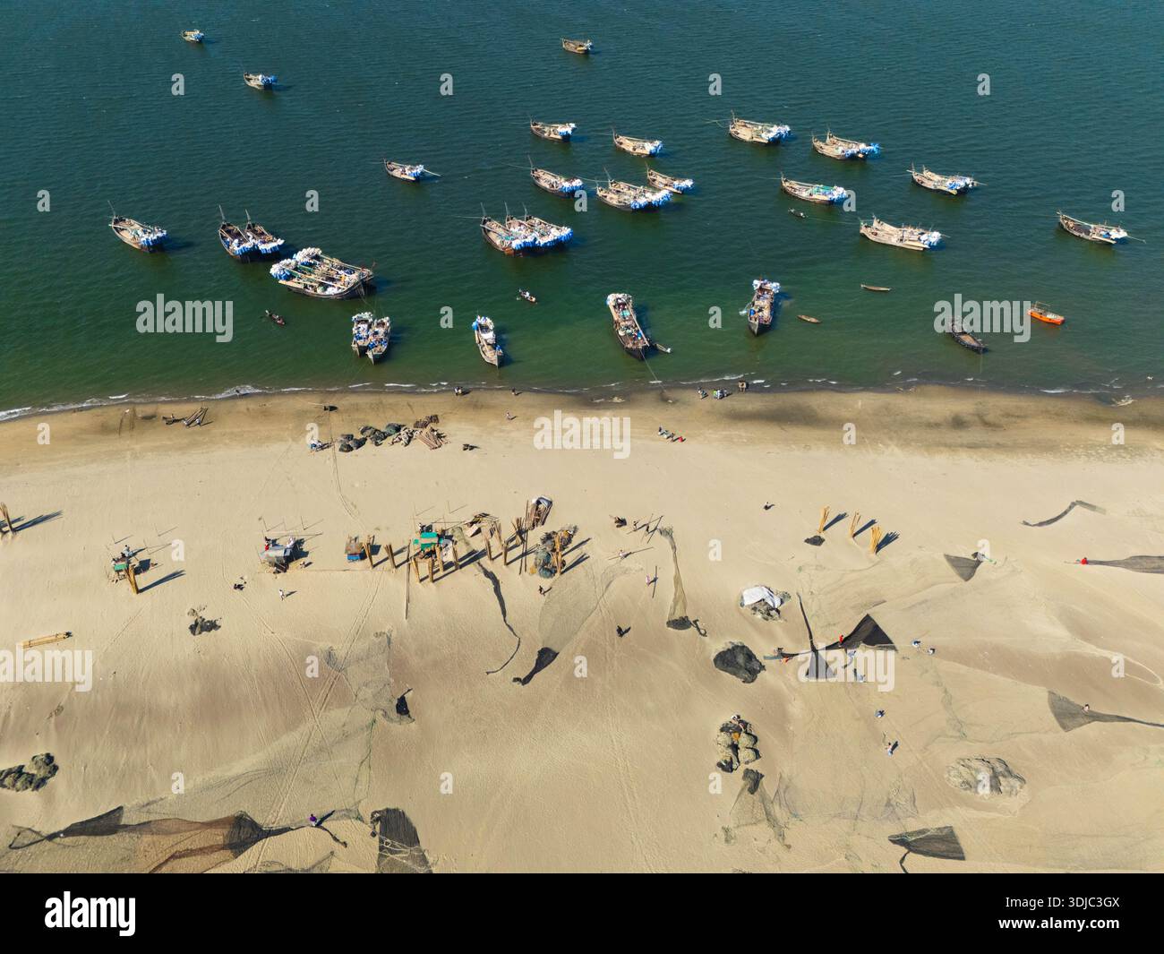 Cox's Bazar, Bangladesh - 8 febbraio 2025: Vista aerea delle barche da pesca che rimbalzano dolcemente sul mare di acquamarina accanto alla spiaggia sabbiosa. Foto Stock