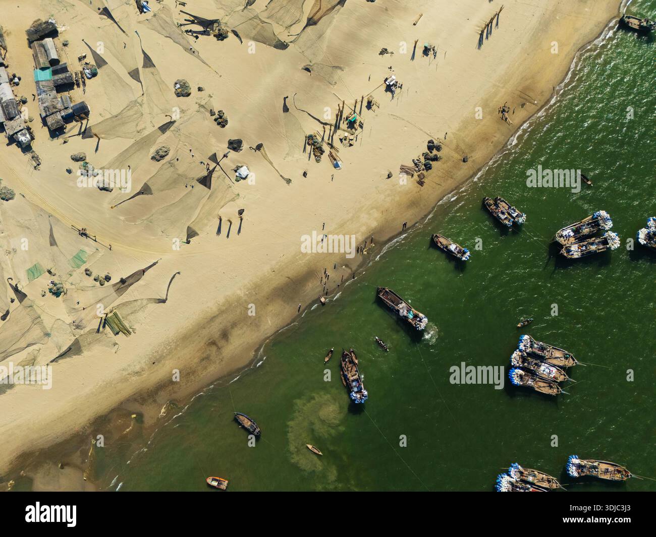 Cox's Bazar, Bangladesh - 8 febbraio 2025: Vista aerea delle barche da pesca che riposano sulla riva, accanto alla spiaggia sabbiosa e alle reti sparse. Foto Stock