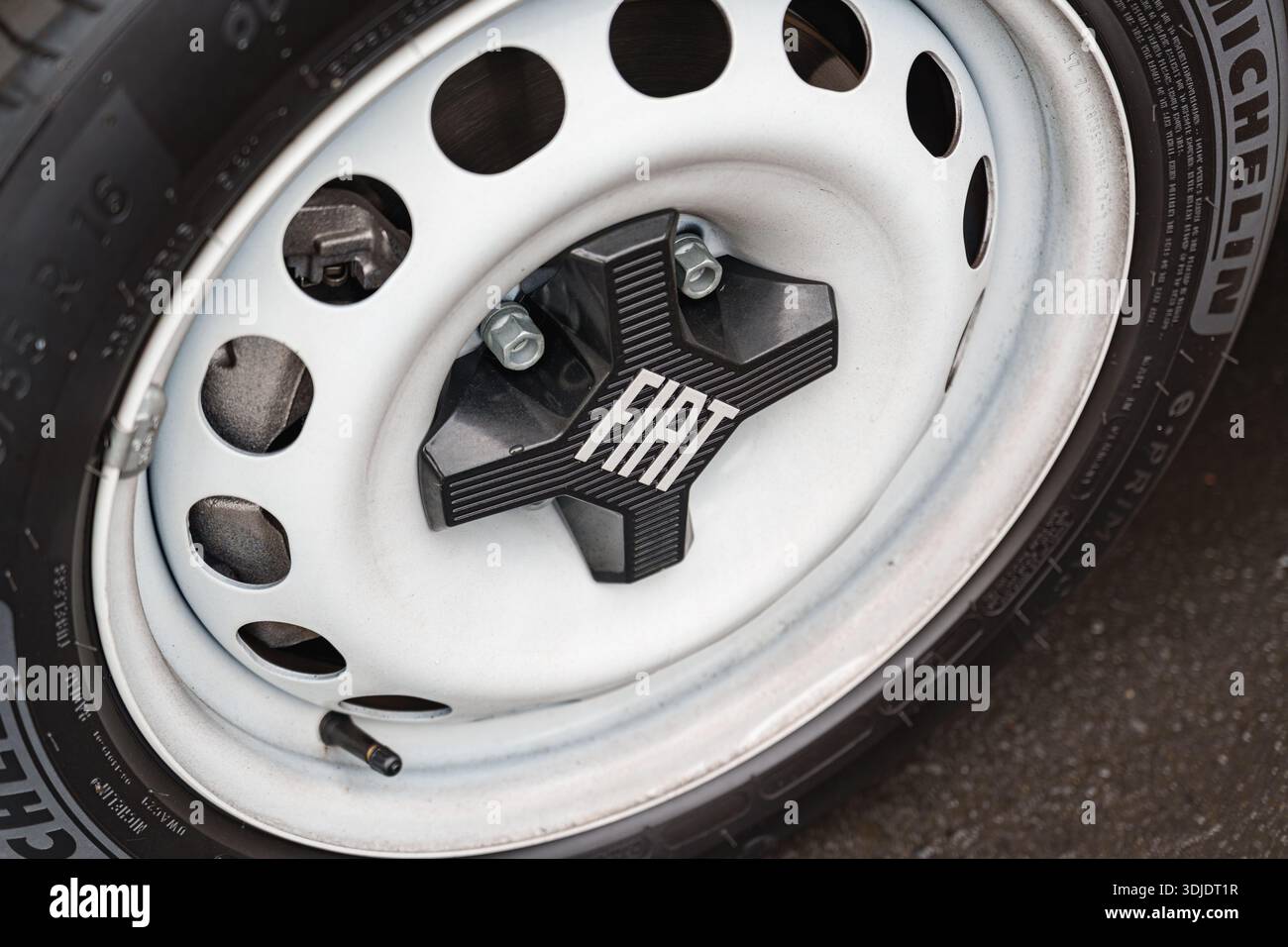 Primo piano del mozzo della ruota Fiat che mostra il design del cerchione in acciaio e del coprimozzo con marchio Foto Stock