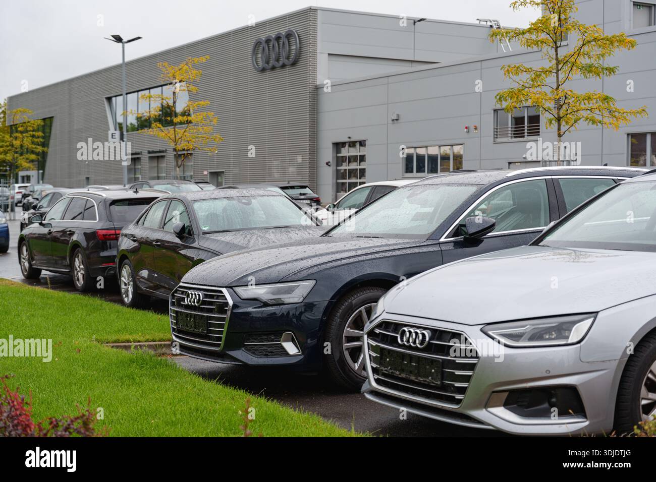 Ampio parcheggio con vetture Audi allineate in file vicino a una concessionaria Foto Stock