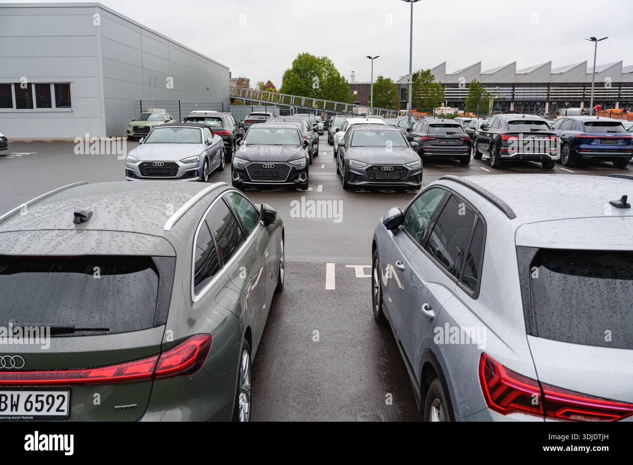 Ampio parcheggio con vetture Audi allineate in file vicino a una concessionaria Foto Stock