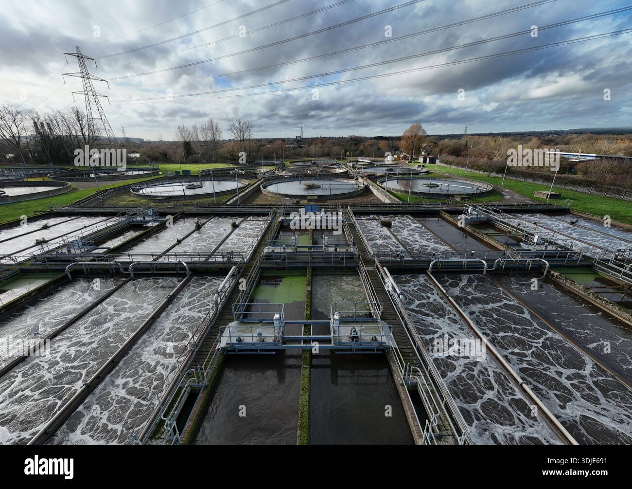 La vista aerea delle piscine rettilinee e circolari per il trattamento delle acque contrasta nettamente con lo sfondo del paesaggio industriale di Hoddesdon, Hoddesdon, un Foto Stock