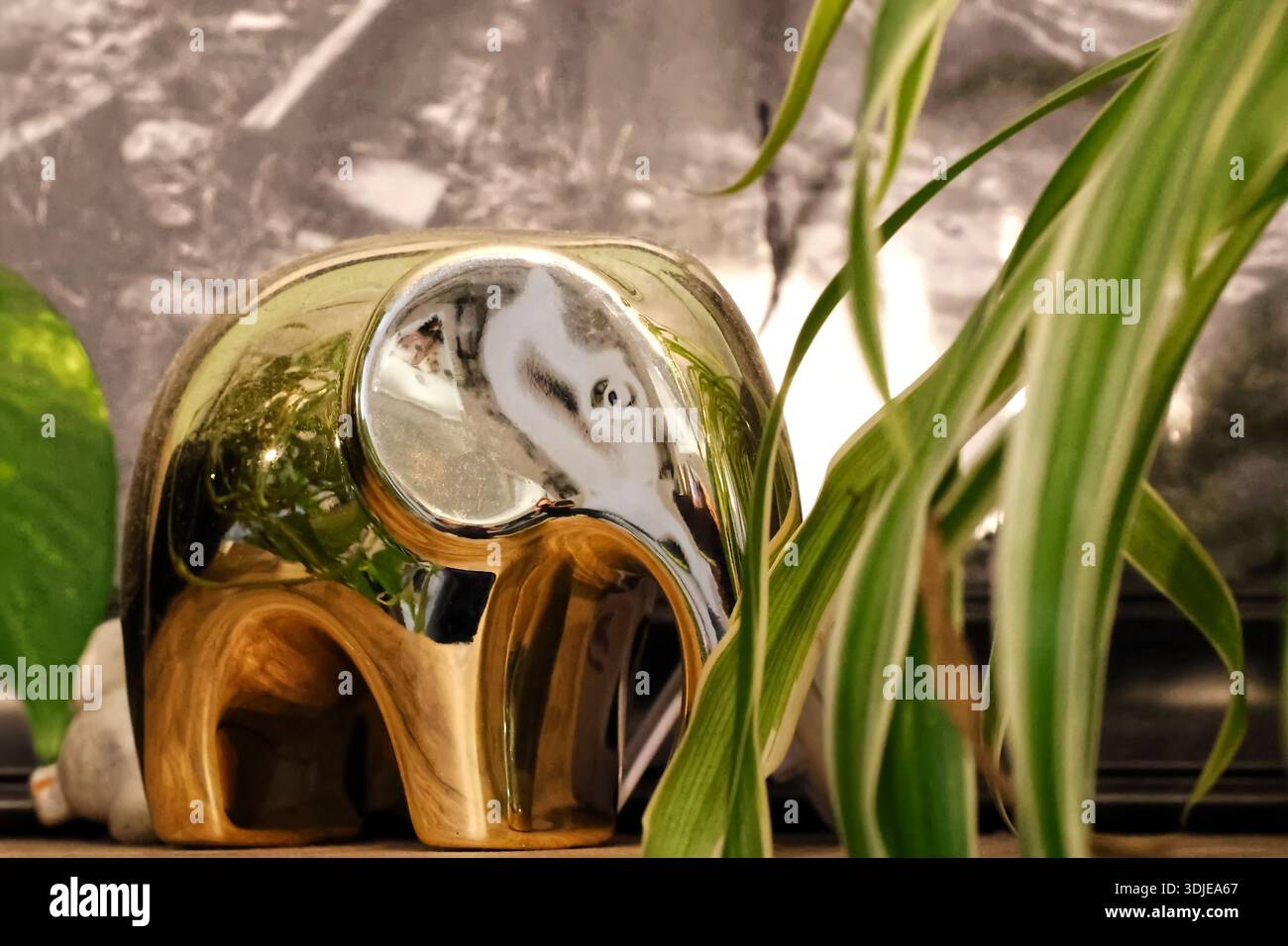 Statua riflettente dell'Elefante d'Oro in mezzo al verde e all'arredamento interno Foto Stock