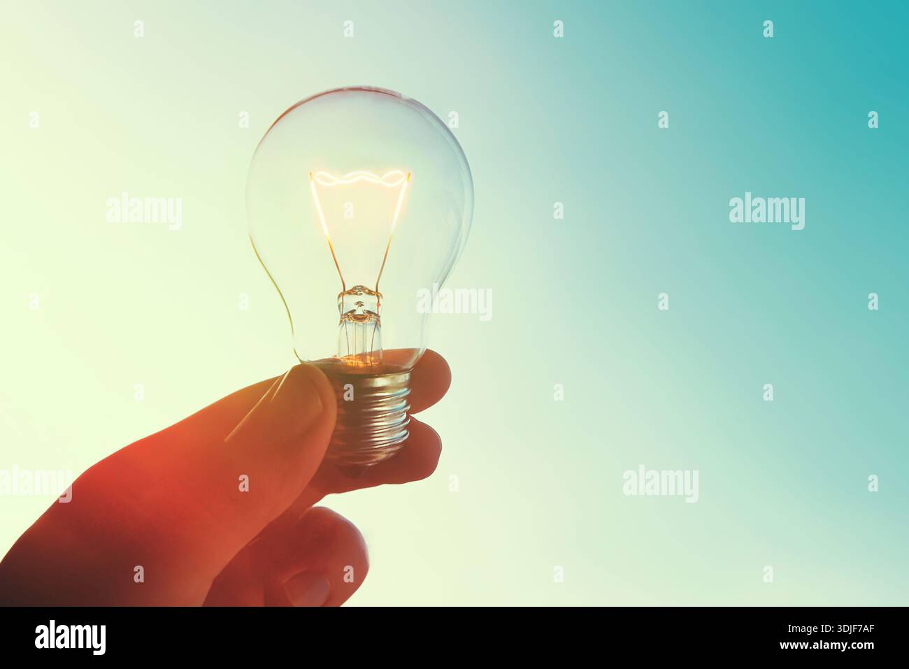 Concetto di crisi energetica globale. L'uomo tiene la lampadina in alto Foto Stock