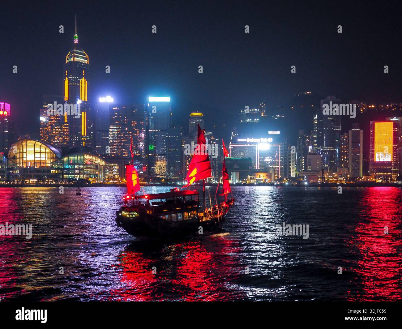Vista notturna di Hong Kong con l'iconica nave spazzatura in primo piano Foto Stock