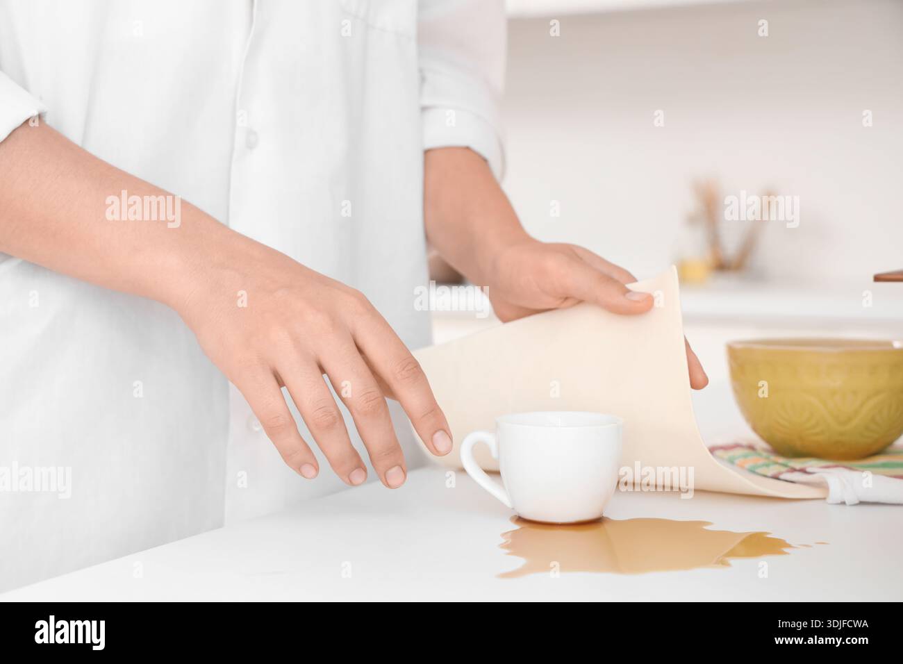 Donna che pulisce il caffè versato sul bancone in cucina, primo piano Foto Stock