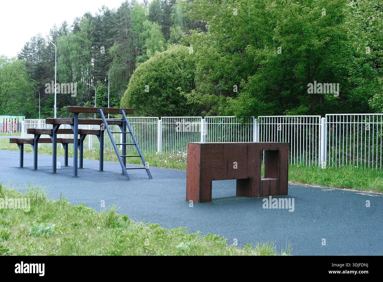 Il percorso ad ostacoli presso il campo di addestramento militare comprende strutture per arrampicata e panchine, situato in uno spazio verde all'aperto, che migliora l'allenamento fisico e te Foto Stock