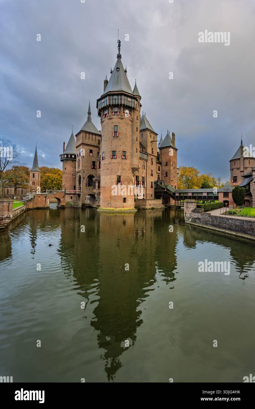 Vista verticale del castello De Haar che si riflette nel fossato circostante, con torri, ponti e un cielo spettacolare a Haarzuilens, Paesi Bassi. Foto Stock