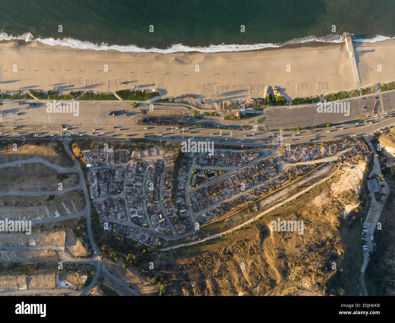 Vista aerea della costa che incontra la comunità residenziale, dove le onde si infrangono dolcemente sulla spiaggia sabbiosa di Pacific Palisades, California, Unit Foto Stock