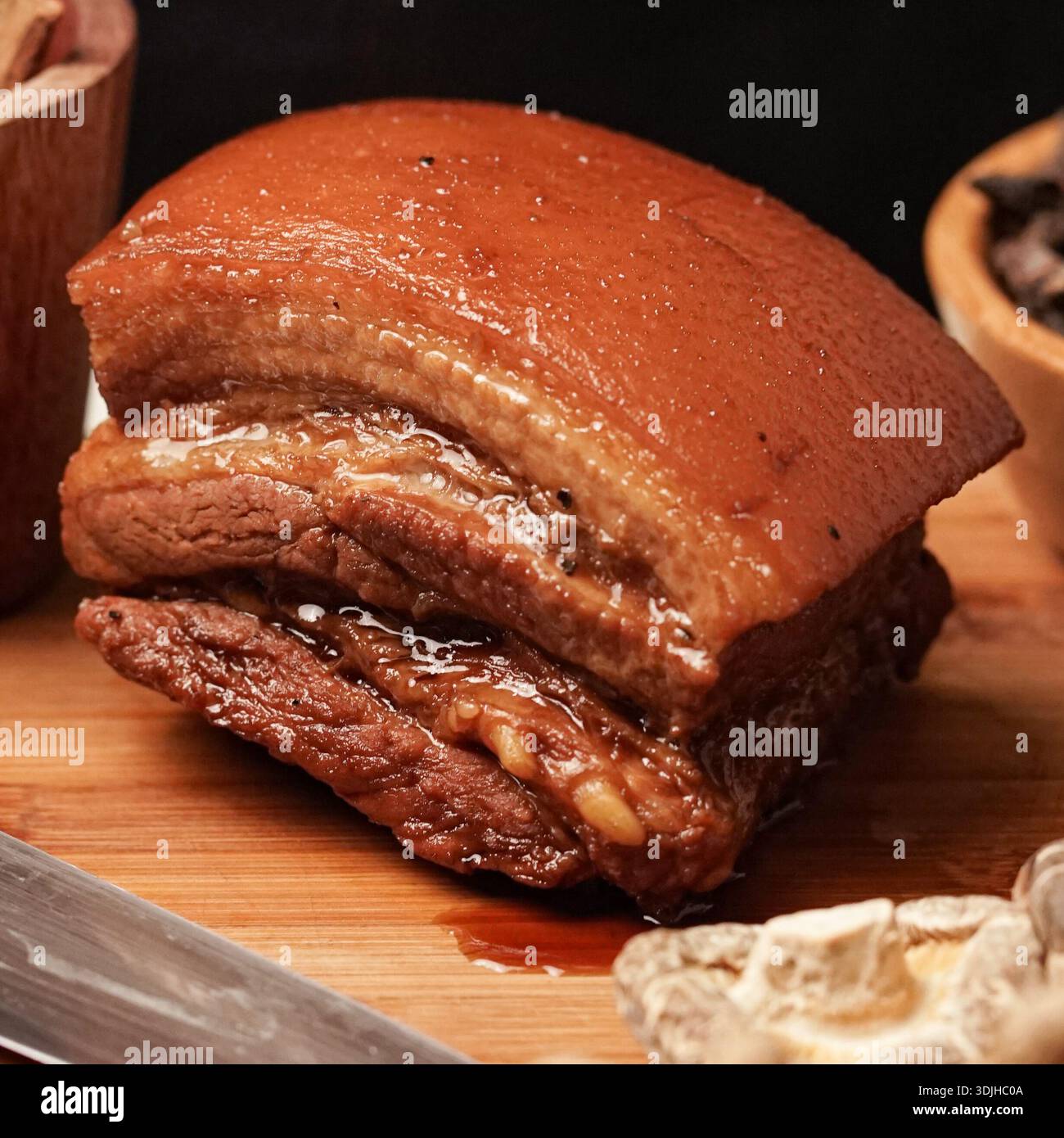 Un allettante primo piano di pancia di maiale perfettamente brasata, con la sua pelle ricca e luccicante e gli strati teneri e succulenti di carne e grasso. Questo tr Foto Stock