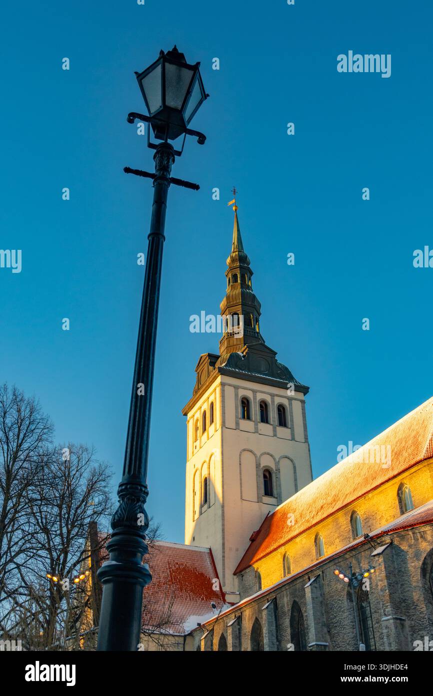 Guardando in alto la guglia della chiesa di San Nicola e il museo Niguliste. Tallinn Estonia, con neve sul tetto, Foto Stock