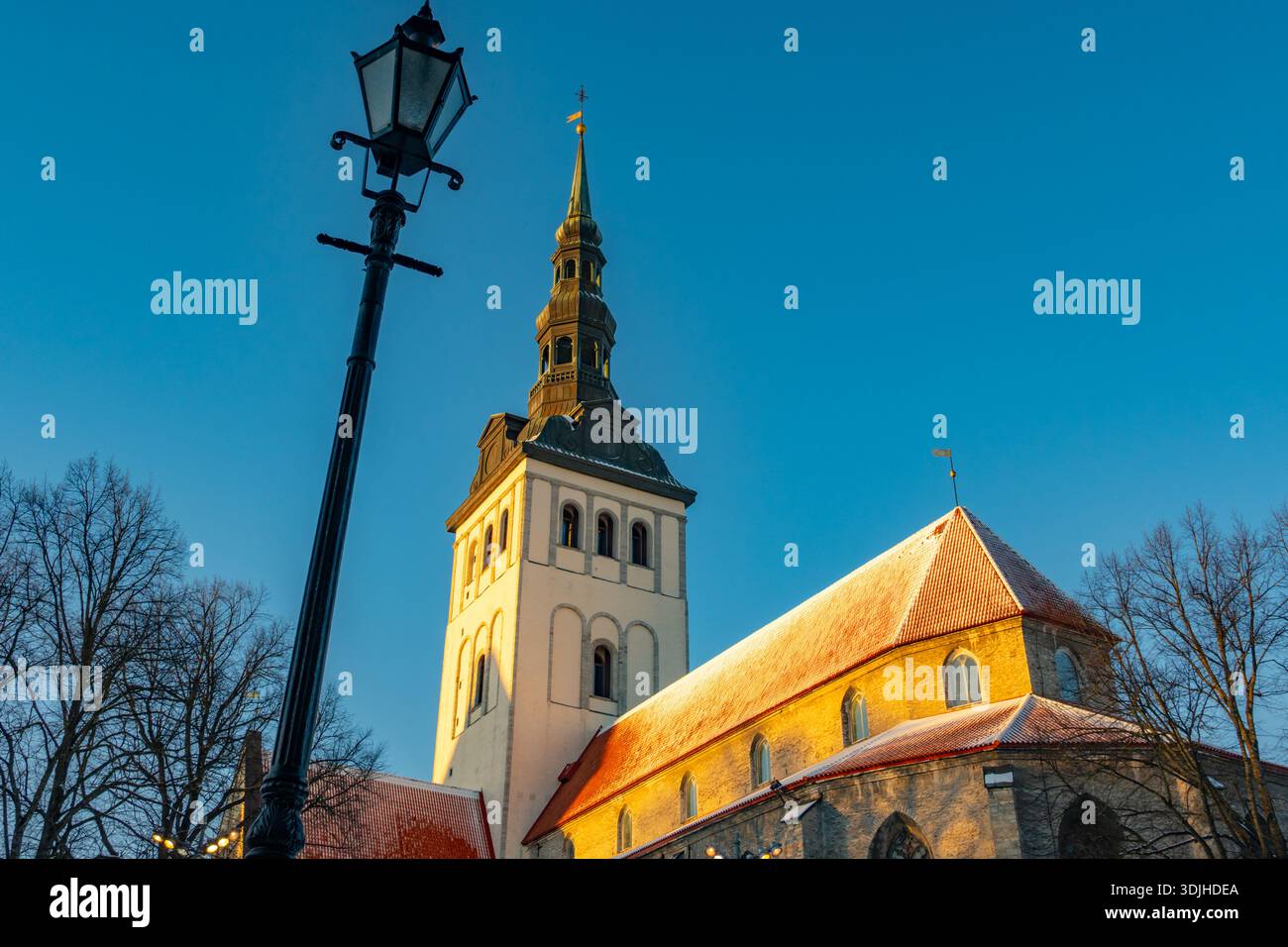 Guardando in alto la guglia della chiesa di San Nicola e il museo Niguliste. Tallinn Estonia, con neve sul tetto, Foto Stock