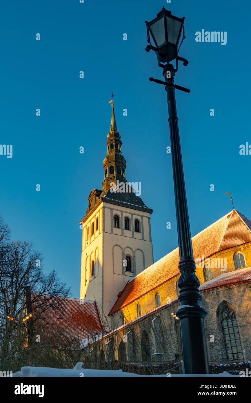 Guardando in alto la guglia della chiesa di San Nicola e il museo Niguliste. Tallinn Estonia, con neve sul tetto, Foto Stock