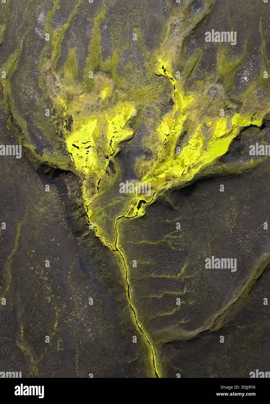 Vista aerea dei depositi minerali di colore giallo vibrante che si snodano attraverso la terra scura e strutturata, creando un netto contrasto di colore e forma, Selfoss, Sveitar Foto Stock