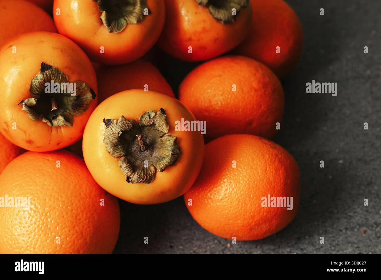 Primi piani di sosia e arance fresche. Fondo di frutta matura di stagione. Cibo sano e naturale ricco di vitamine. Consistenza dei frutti del raccolto autunnale. Foto Stock