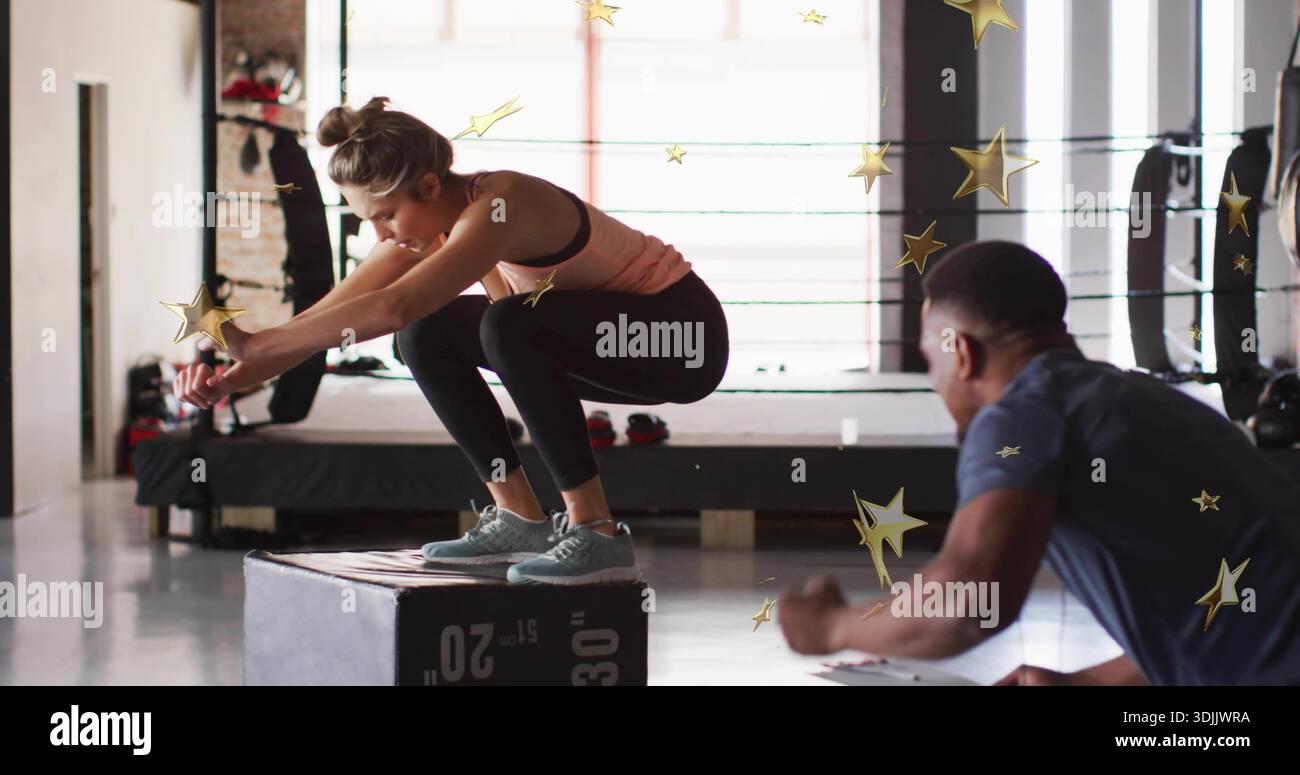 Donna che tiene uno squat su plyo box in palestra vicino all'anello di pugilato e indossa una canotta di pesca Foto Stock