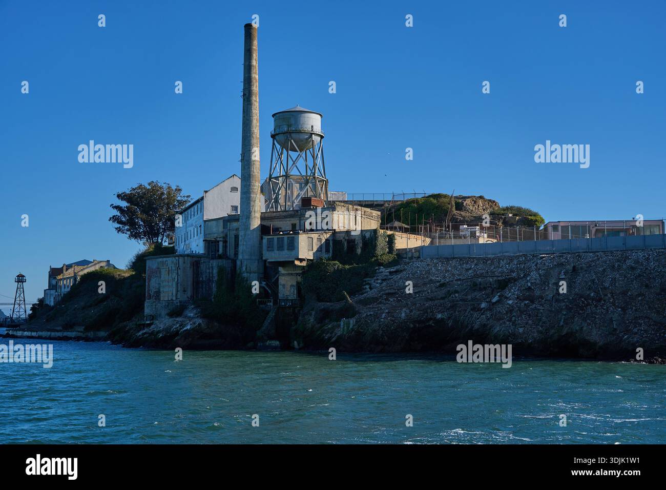 San Francisco, Stati Uniti - 27 ottobre 2025 - complesso carcerario dell'isola di Alcatraz con torre dell'acqua e campo da fumo in una giornata limpida Foto Stock