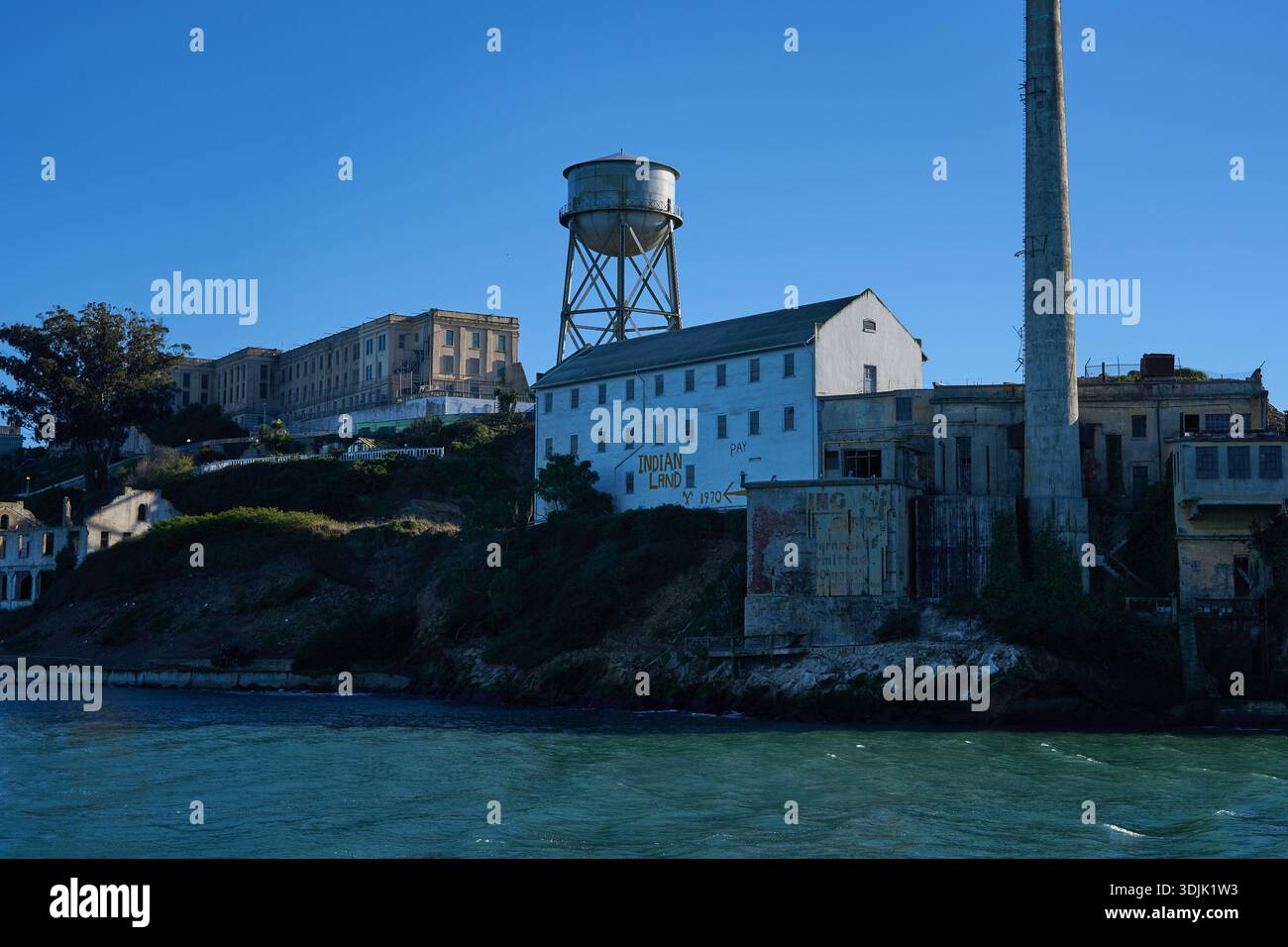 San Francisco, Stati Uniti - 27 ottobre 2025 - complesso carcerario dell'isola di Alcatraz con torre dell'acqua e campo da fumo in una giornata limpida Foto Stock