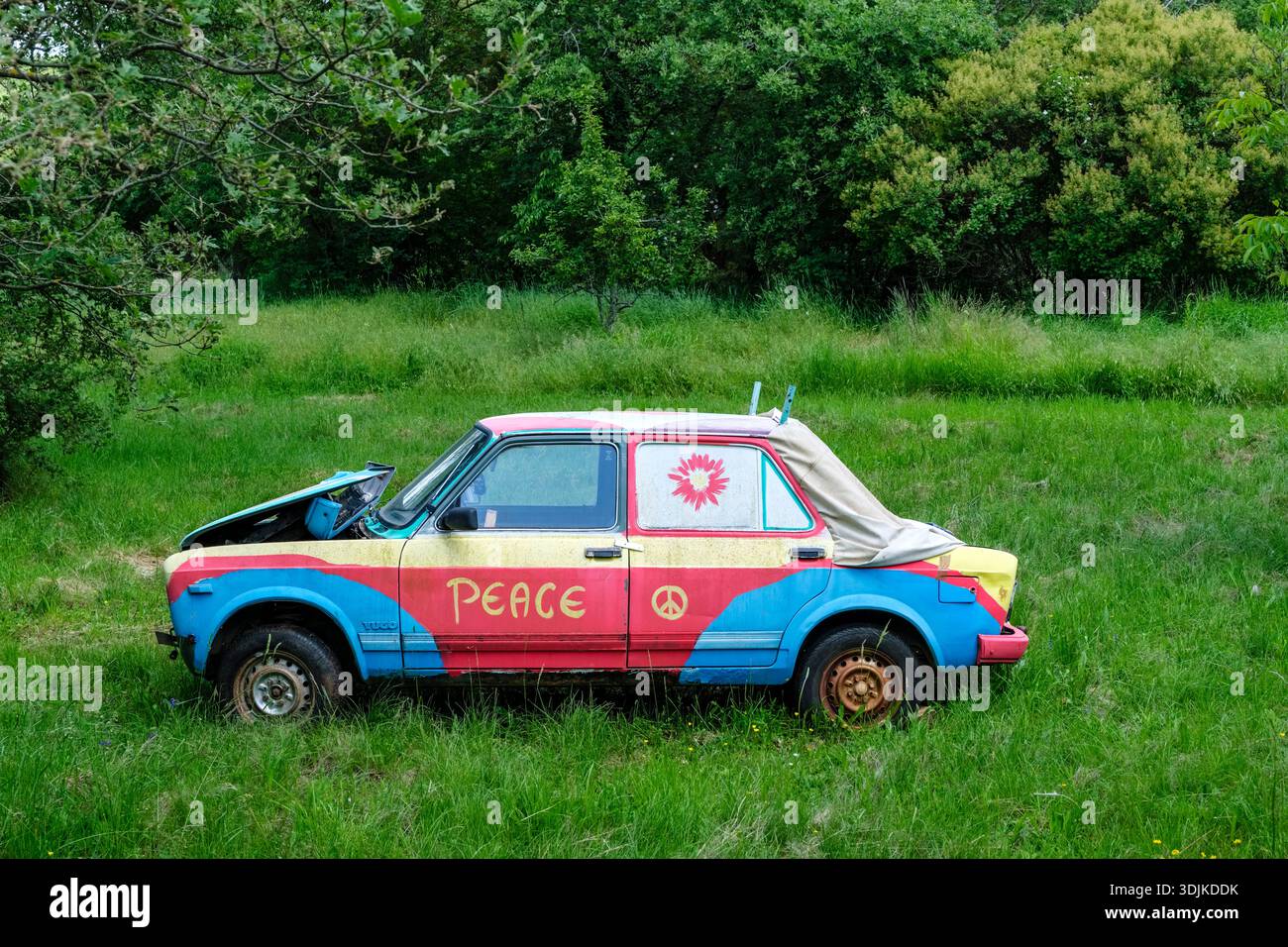 Un'auto Lada colorata con la parola PACE e un simbolo di pace si trova in un prato verde vicino a Grožnjan. Foto Stock