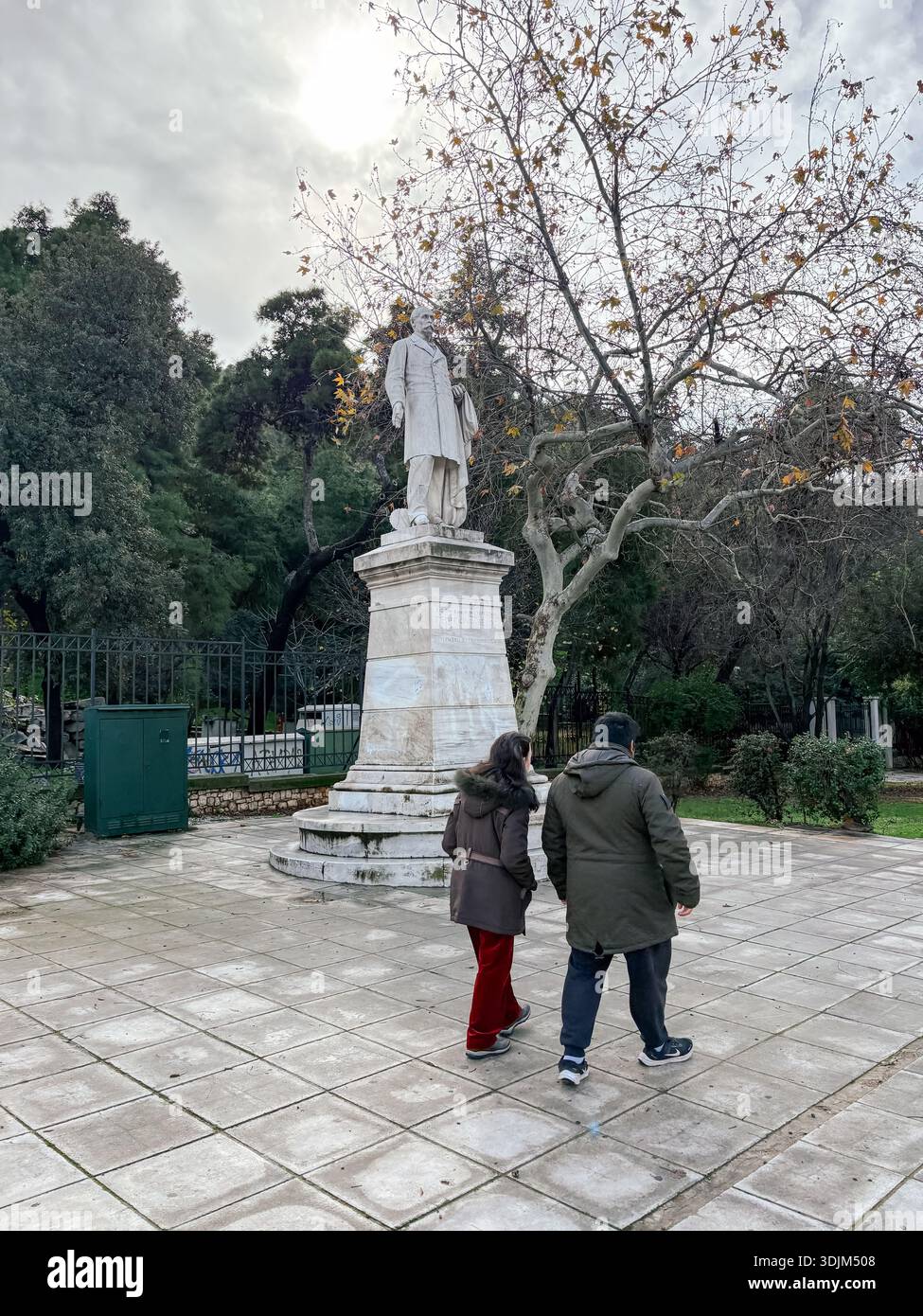 Statua di Charilaos Trikoupis, influente primo ministro greco. Due persone passeranno davanti al monumento in una piazza pubblica o parco, Atene, Grecia. Foto Stock