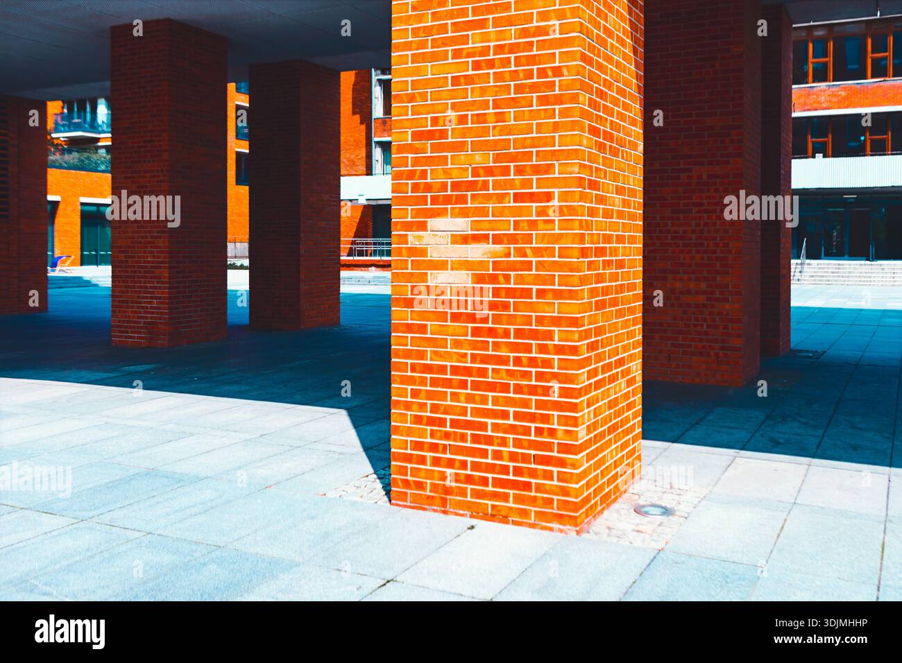 Colonne da costruzione in mattoni rossi. Architettura moderna con grandi colonne quadrate in mattoni rossi e un cortile lastricato. E' un'architettura contemporanea Foto Stock