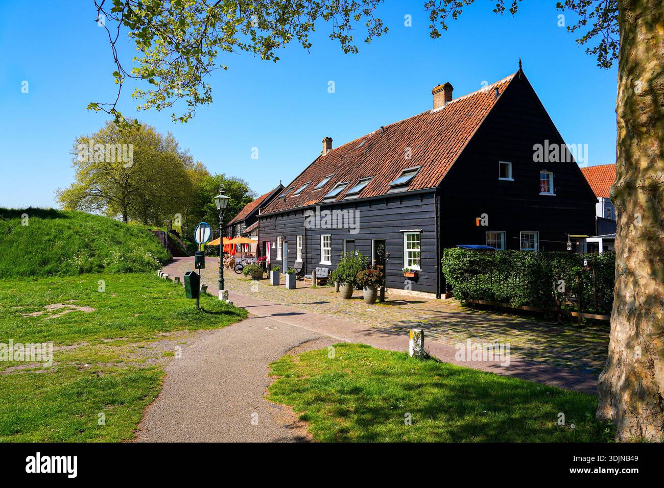 Tradizionale casa in legno nero vicino alle storiche mura della città di Brielle, Olanda meridionale, Paesi Bassi Foto Stock