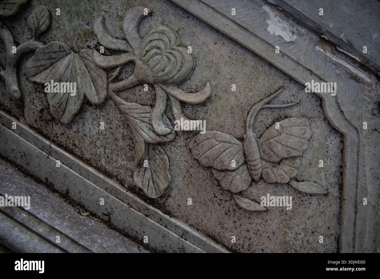 Un pannello di pietra con una farfalla e un fiore scolpiti nella montagna Xishan, Kunming, Yunnan, Cina. Foto Stock