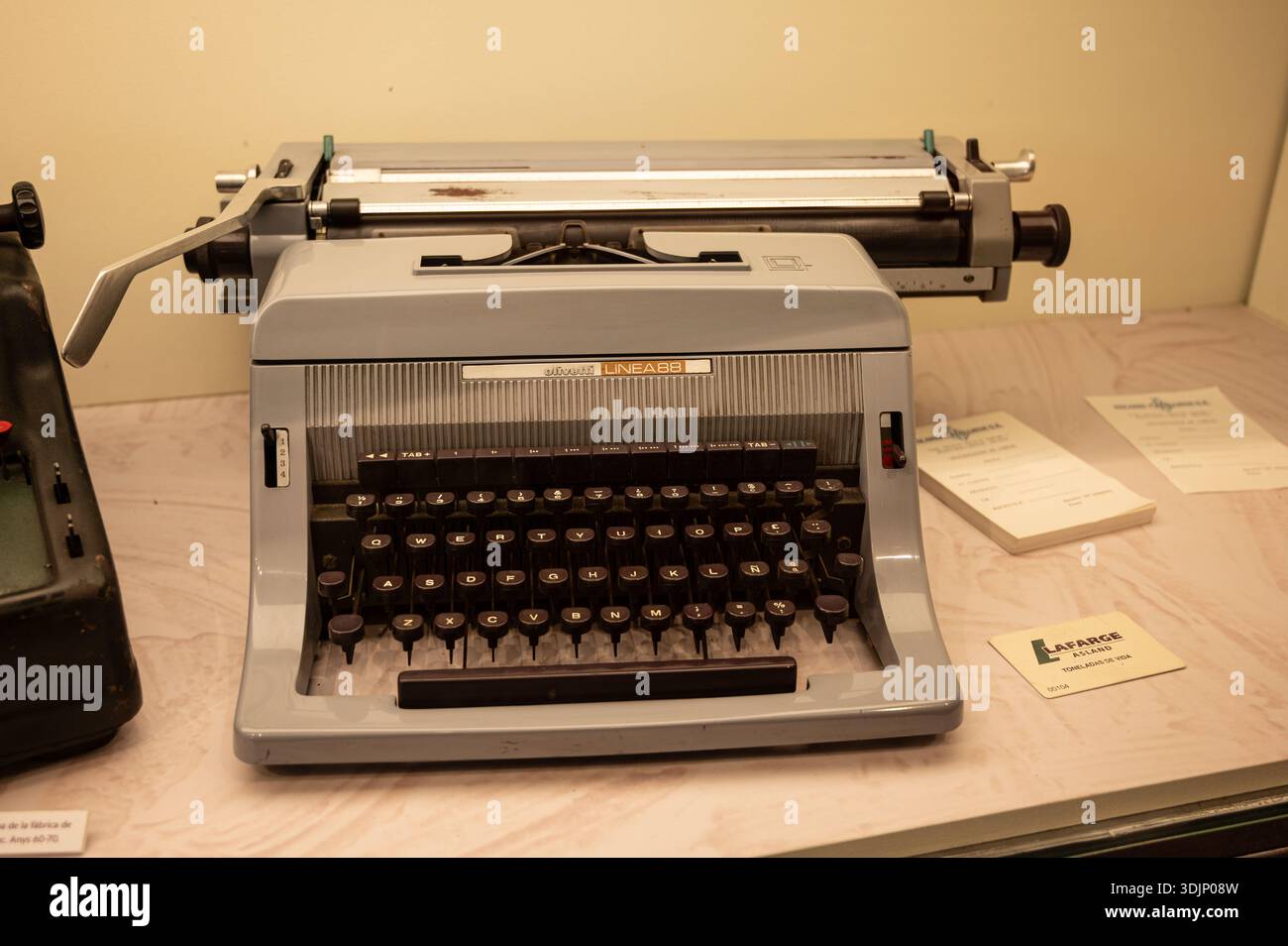 Macchina da scrivere Olivetti linea 88 d'epoca su una scrivania di colore chiaro, esposta con vecchie carte e articoli da ufficio in uno scatto ravvicinato Foto Stock