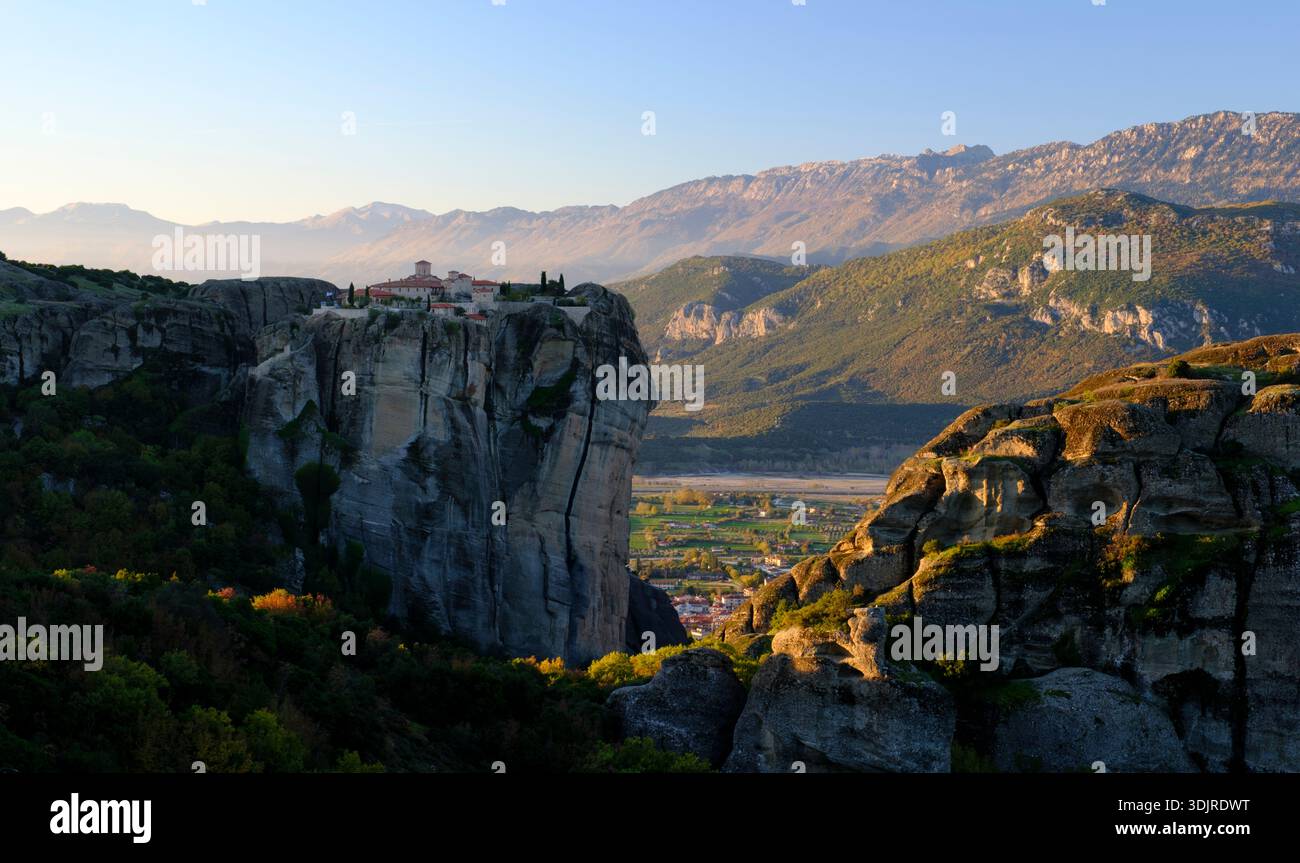 Il Monastero della Santissima Trinità, arroccato su una torreggiante roccia di Meteora all'alba, con catene montuose che svaniscono in lontananza, Tessaglia, Grecia Foto Stock