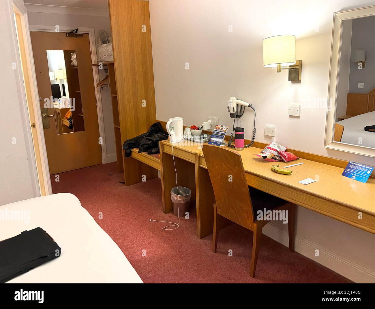 Una semplice sistemazione interna delle camere dell'hotel Days Inn, dotata di scrivania, bollitore e servizi essenziali per i viaggiatori che hanno bisogno di uno spazio confortevole Foto Stock