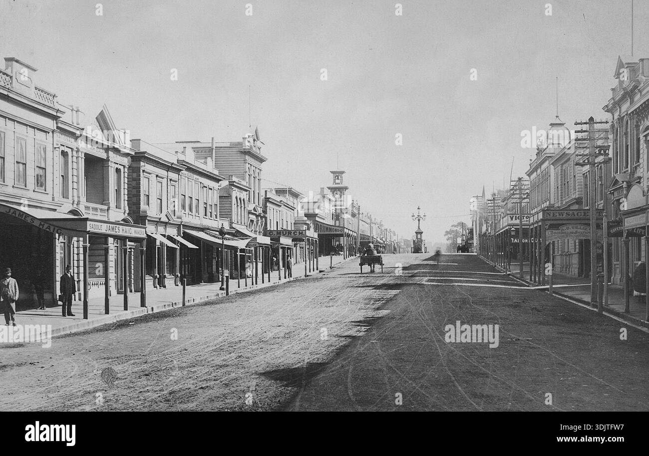Questa è Victoria Avenue, alias The Avenue, a Wanganui, nuova Zelanda (sull'Isola del Nord). A partire dagli anni '1800, Victoria Avenue a Whanganui era il principale centro commerciale, con vari negozi, aziende ed edifici coloniali. L'edificio della torre dell'orologio al centro era il Chief Post Office, che fu completato nel 1902. La torre fu rimossa nel 1931 dopo un terremoto. Il nome originale della città era Petre, dal nome di un europeo. Fu cambiato nel 1854 con il nome Maori esistente, che significa "la lunga attesa" Foto Stock