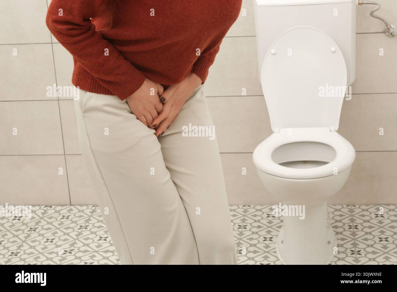 Donna che soffre di dolori addominali e vescicali inferiori in bagno – concetto di infezione delle vie urinarie, cistite, crampi e disagio digestivo Foto Stock