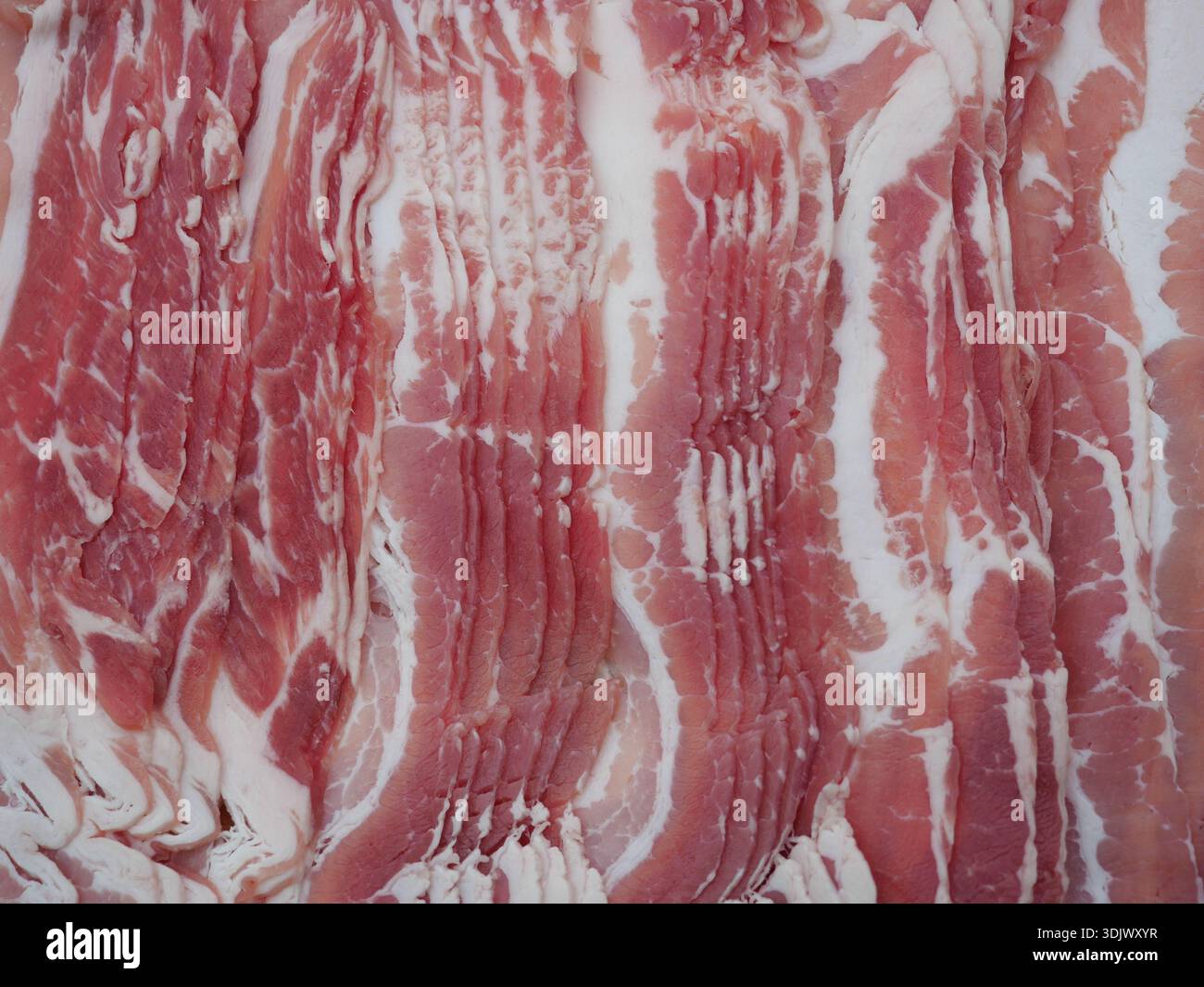 Pancetta di maiale affumicata per una cucina sostanziosa e piatti salati. Per grigliare, cuocere e arrostire. Primo piano. Copyspace. Foto Stock