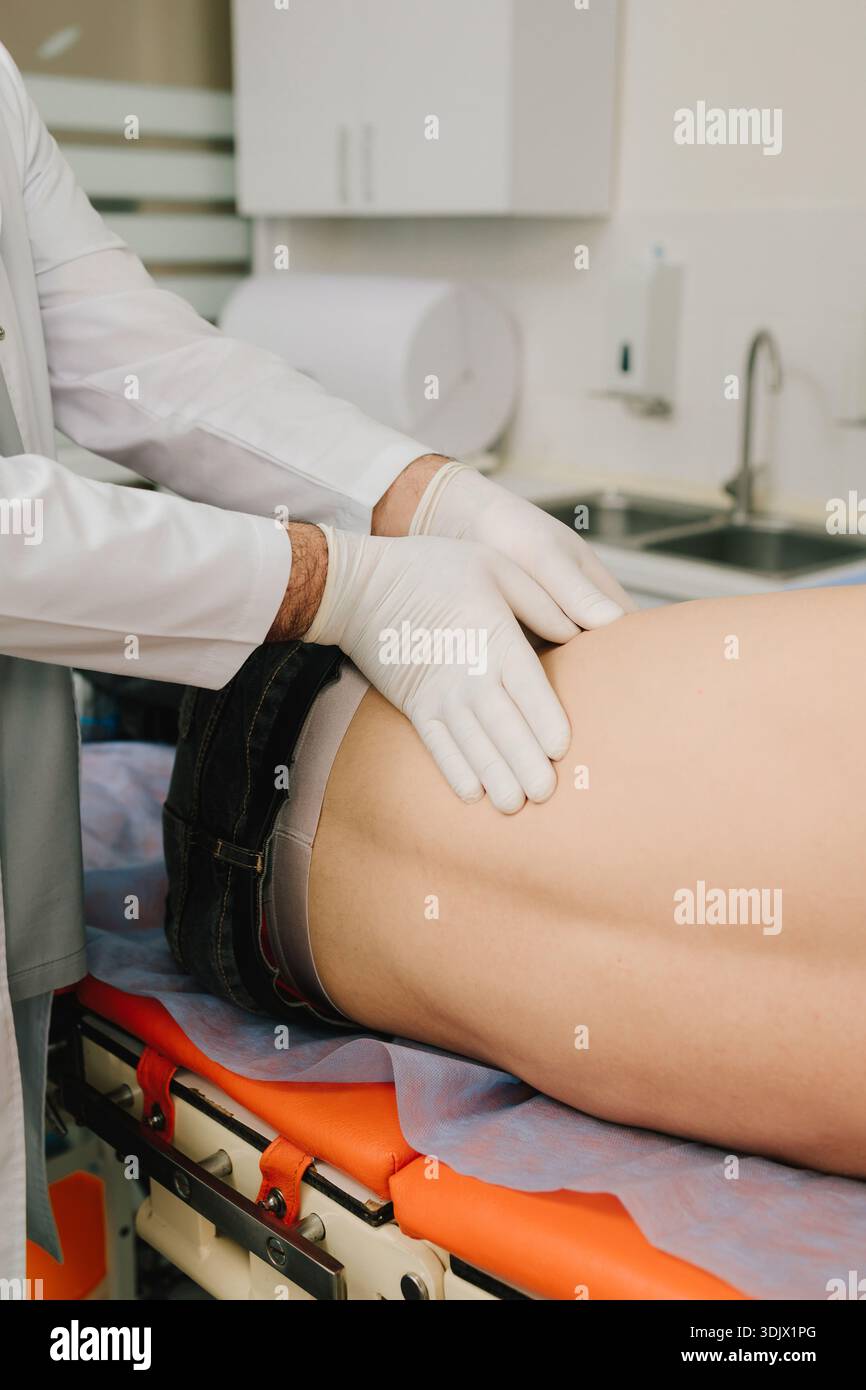 L'urologo esamina i reni maschili distesi sulla schiena per verificare le dimensioni del dolore o l'infiammazione Foto Stock