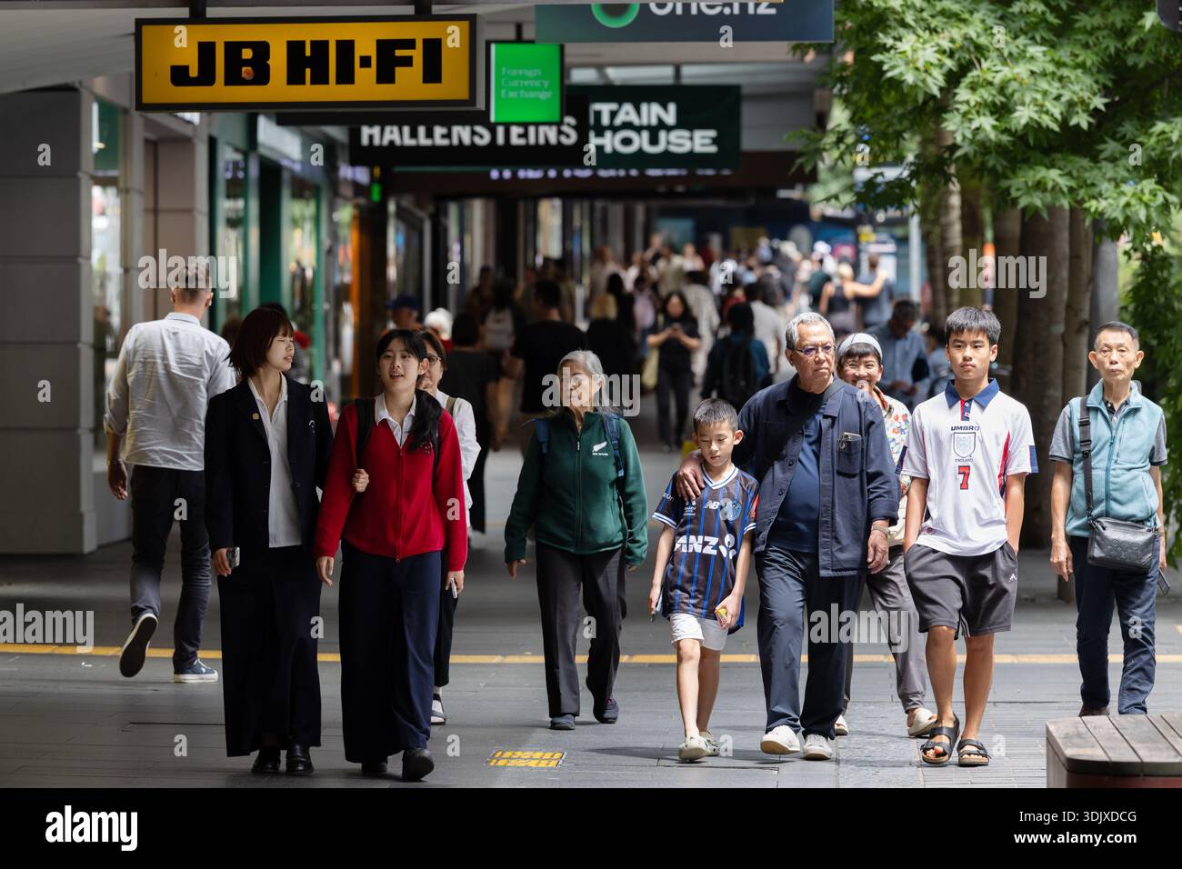 I pedoni camminano lungo Queen Street ad Auckland, nuova Zelanda, passando per negozi e negozi nel principale quartiere dello shopping della città. Foto Stock