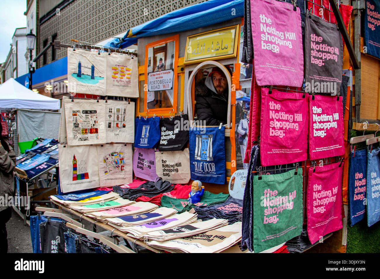 Le colorate borse per lo shopping e le borse artistiche di Notting Hill sono esposte in un vivace mercato di strada in Portobello Road, Londra, Regno Unito. Foto Stock