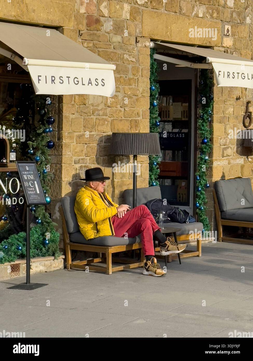 Un uomo vestito coloratamente di giallo e rosso - Firenze, Italia Foto Stock